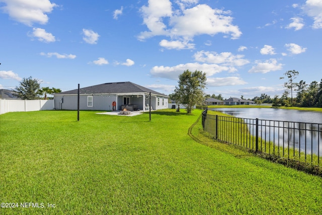 view of yard featuring a patio, a water view, and a fenced backyard