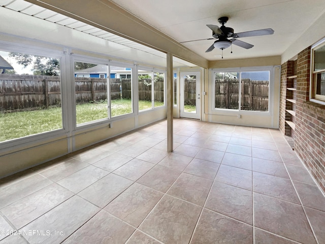 unfurnished sunroom with plenty of natural light and ceiling fan