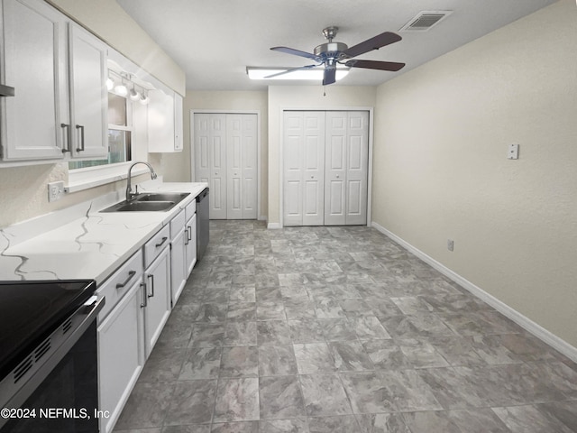 kitchen with baseboards, visible vents, dishwasher, white cabinets, and a sink