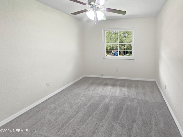 unfurnished room featuring carpet floors, a ceiling fan, and baseboards