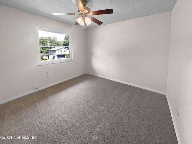 carpeted empty room with a ceiling fan, a textured ceiling, and baseboards