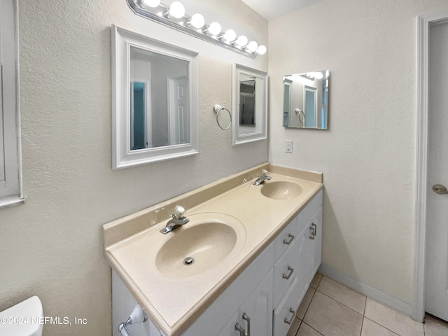 bathroom with tile patterned flooring, a sink, toilet, and double vanity