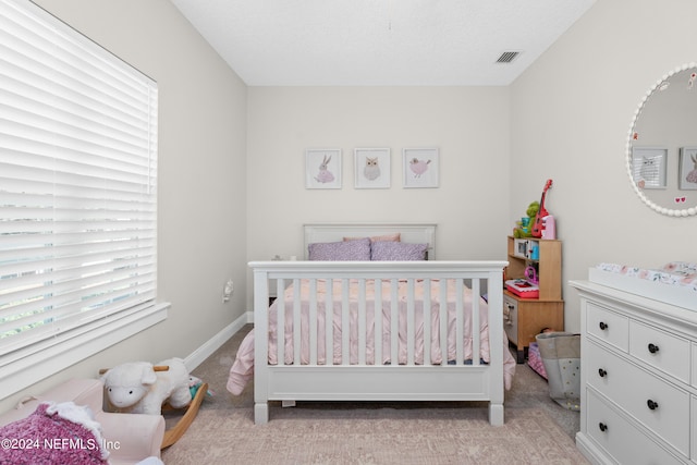 bedroom featuring light carpet, visible vents, and baseboards