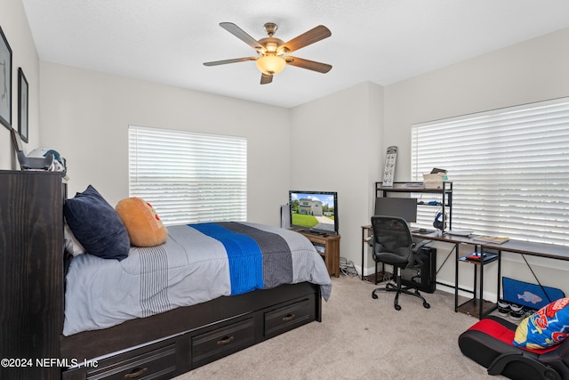 carpeted bedroom with multiple windows, baseboards, and a ceiling fan