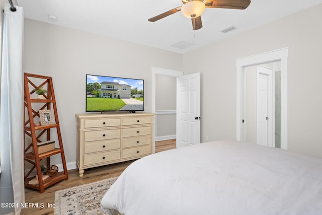 bedroom with baseboards, wood finished floors, visible vents, and a ceiling fan