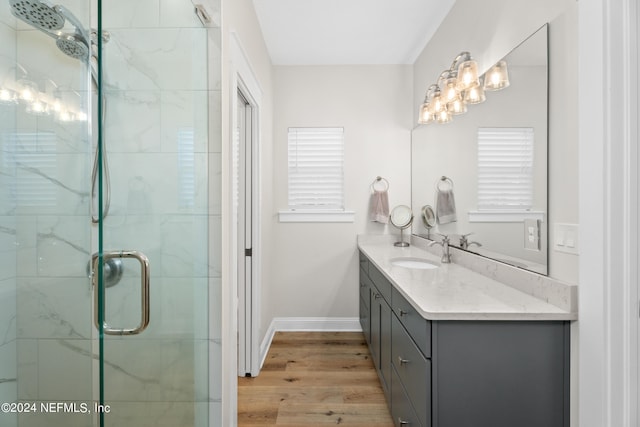 full bath with baseboards, a shower stall, vanity, and wood finished floors