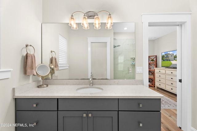 full bath featuring wood finished floors, a shower stall, and vanity