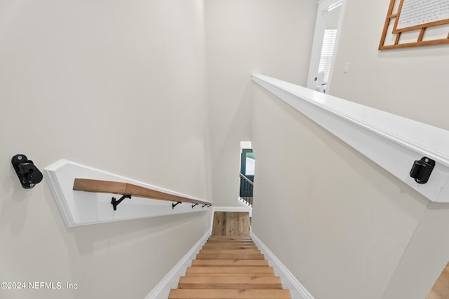 stairs with baseboards, wood finished floors, and a healthy amount of sunlight