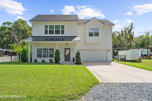 modern farmhouse style home with a garage, concrete driveway, fence, a front lawn, and board and batten siding