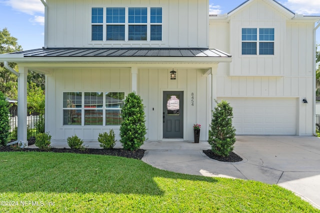 modern inspired farmhouse with a standing seam roof, board and batten siding, and a front yard