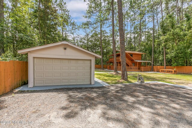 garage featuring a yard and wooden walls