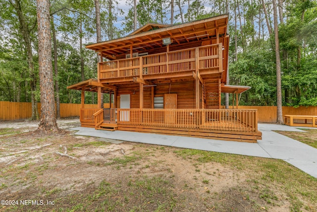 view of front of home featuring a wooden deck and a patio