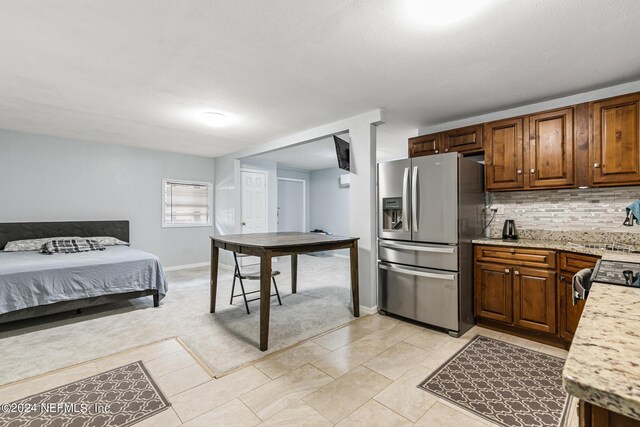 kitchen with light stone counters, light tile patterned floors, appliances with stainless steel finishes, and decorative backsplash