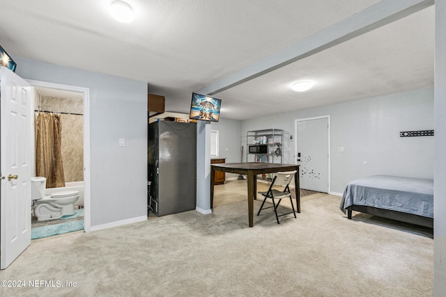 bedroom featuring light carpet and connected bathroom