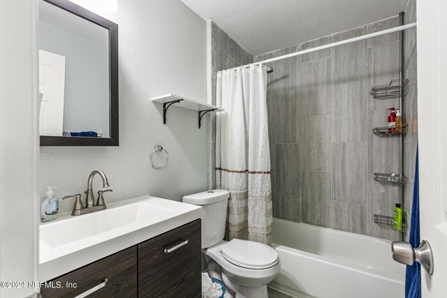 full bathroom featuring a textured ceiling, vanity, toilet, and shower / bath combo with shower curtain