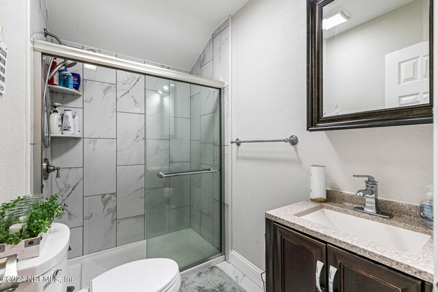 bathroom with a shower with shower door, vaulted ceiling, toilet, and vanity