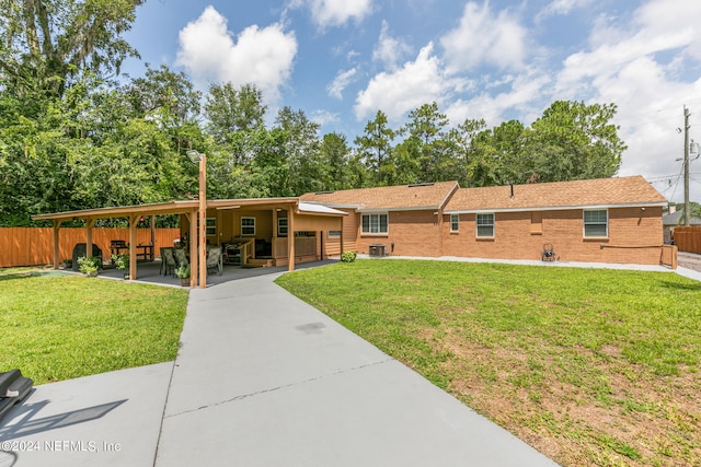 view of front of property with cooling unit, a carport, and a front yard