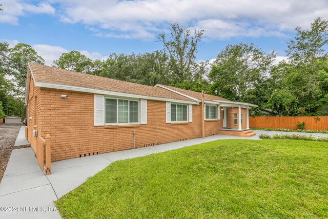 single story home with a front yard and a patio area