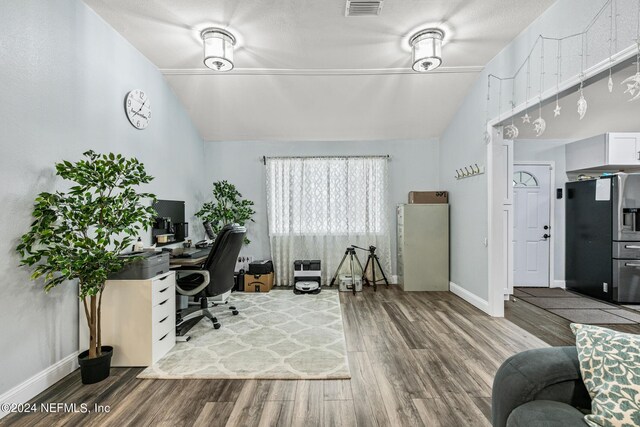 home office featuring vaulted ceiling and hardwood / wood-style flooring