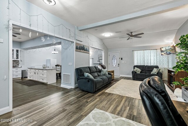 living room featuring ceiling fan, dark hardwood / wood-style floors, and lofted ceiling with beams