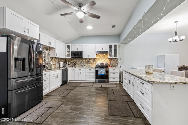 kitchen featuring ceiling fan with notable chandelier, light stone counters, white cabinetry, lofted ceiling, and black appliances