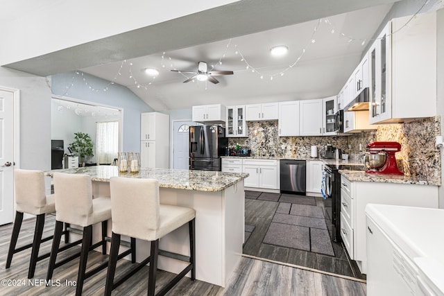 kitchen with white cabinets, appliances with stainless steel finishes, dark hardwood / wood-style flooring, lofted ceiling, and a kitchen island