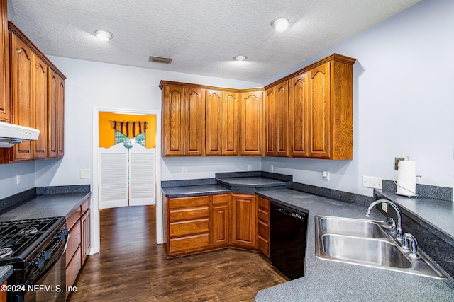 kitchen with a textured ceiling, black appliances, dark hardwood / wood-style floors, and sink