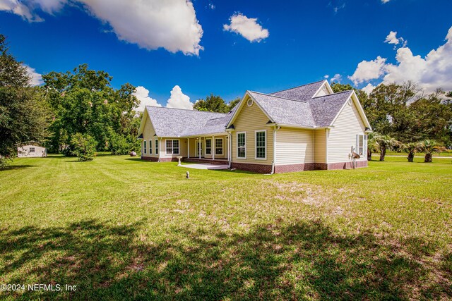 back of property featuring a yard and a patio area