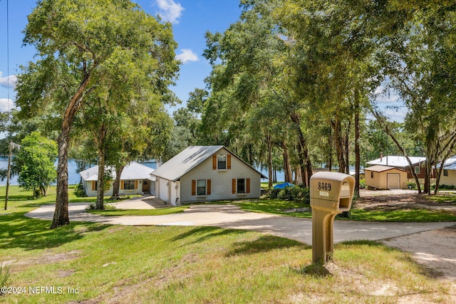 view of front of house with concrete driveway and a front lawn