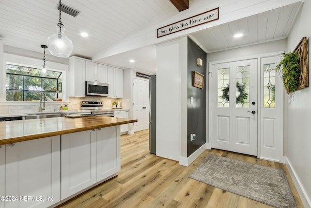 kitchen featuring pendant lighting, white cabinetry, light hardwood / wood-style flooring, sink, and appliances with stainless steel finishes