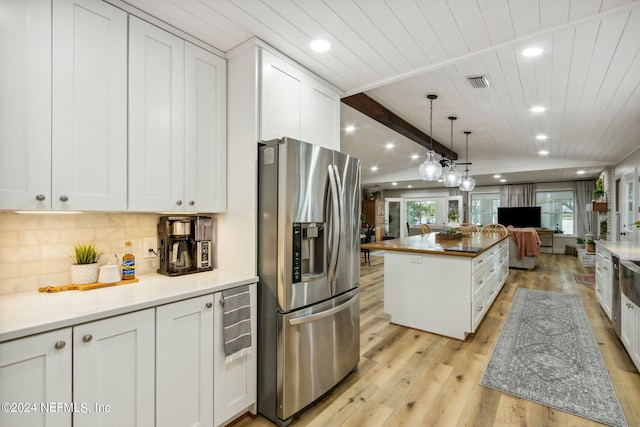 kitchen with light wood-type flooring, stainless steel fridge, a center island, beam ceiling, and white cabinets