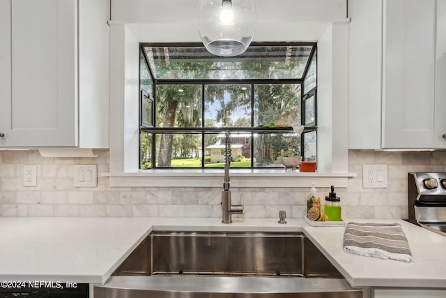 kitchen with white cabinetry, light stone countertops, and decorative backsplash