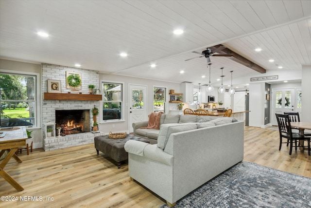 living room featuring a fireplace, a healthy amount of sunlight, and ceiling fan