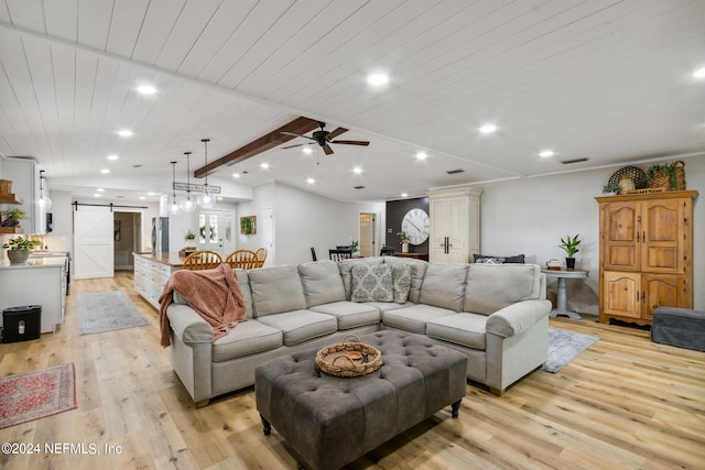 living room with beamed ceiling, wooden ceiling, light hardwood / wood-style floors, a barn door, and ceiling fan