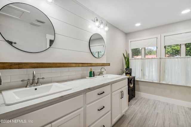 bathroom with vanity, wood-type flooring, and tasteful backsplash