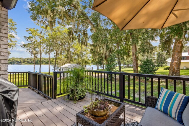 wooden terrace featuring a water view and grilling area