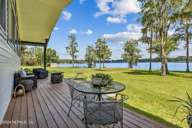 wooden deck with a water view and a yard