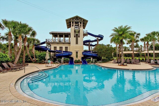 view of pool featuring a water slide and a patio area