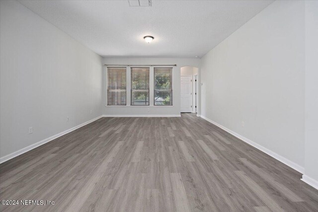 spare room featuring wood-type flooring and a textured ceiling