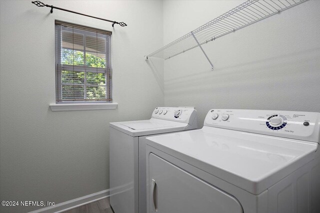 washroom featuring washing machine and dryer and wood-type flooring