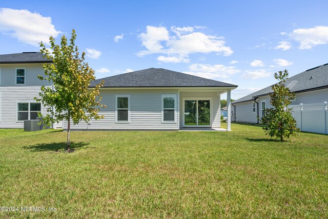 rear view of property featuring a lawn, a patio, and central air condition unit