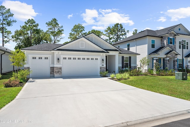 craftsman house with a front yard and a garage