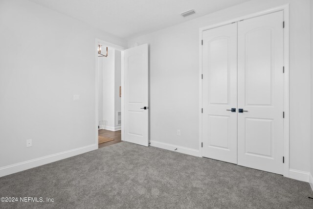 unfurnished bedroom with carpet and a closet