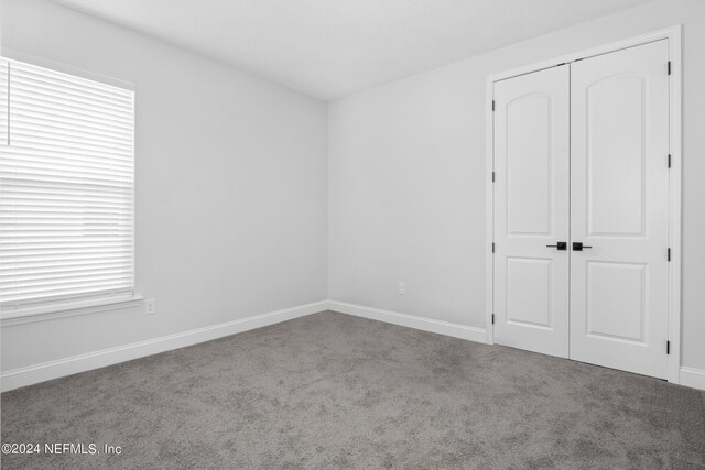 unfurnished bedroom featuring a closet and carpet floors