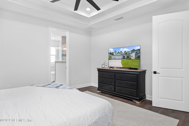 bedroom featuring dark hardwood / wood-style flooring, connected bathroom, and ceiling fan