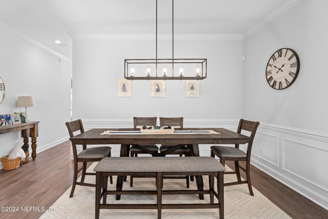 dining room featuring ornamental molding, wood-type flooring, and a chandelier