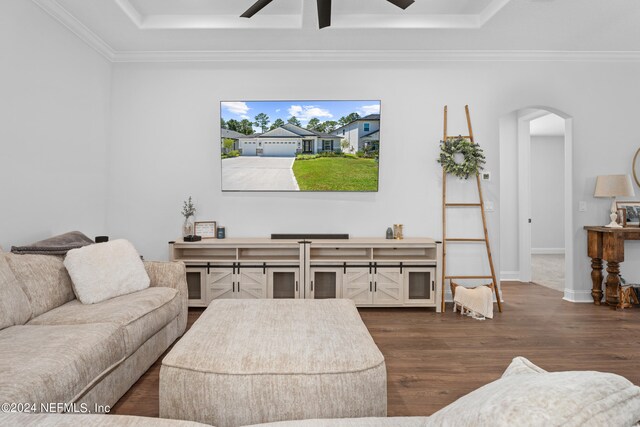 living room featuring crown molding, dark wood-type flooring, and ceiling fan