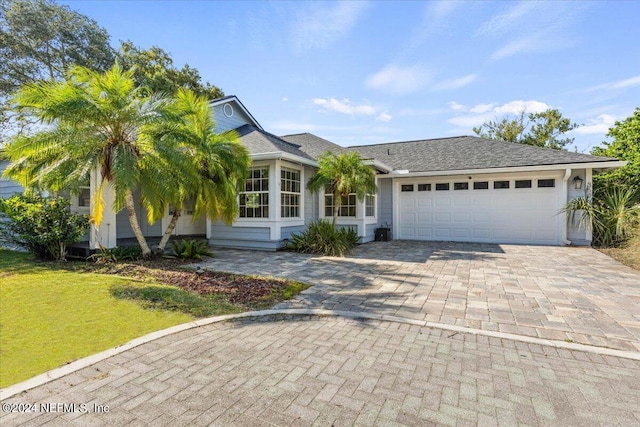 view of front of house featuring a garage and a front lawn