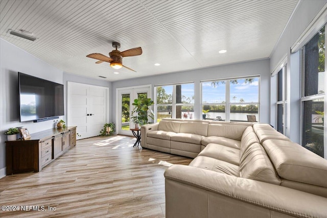 living room featuring light wood-type flooring, ornamental molding, and ceiling fan