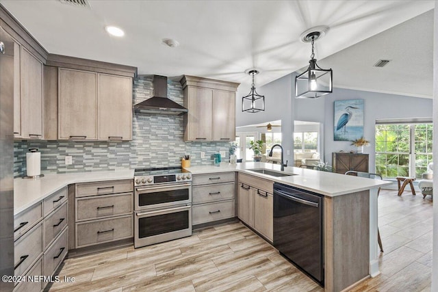 kitchen with black dishwasher, double oven range, kitchen peninsula, sink, and wall chimney range hood